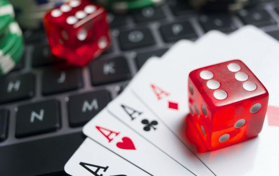 Настольные игры в интернет казино На клавиатуре ноутбука разложены тузы всех мастей и красные кубики для крэпса