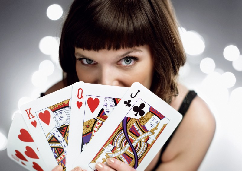 Сексуальная девушка позирует с картами в руках